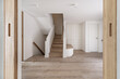 views of a large hall of a recently renovated modern house with a white oak wooden bench with drawers, a white wardrobe next to stairs to go up and others to go down