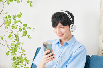 Poster - 自宅でスマートフォンで音楽を聴く男性