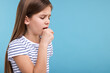 Sick girl coughing on light blue background, space for text