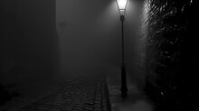 A Lone Streetlamp In A Misty Alley