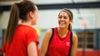 © nilanka - Two young female athletes laughing in the training session indoor stadium. Generative ai