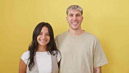 Poster - Happy, confident couple sharing toothy grins standing against isolated yellow background. beautiful duo, radiating positivity and looking cheerful.