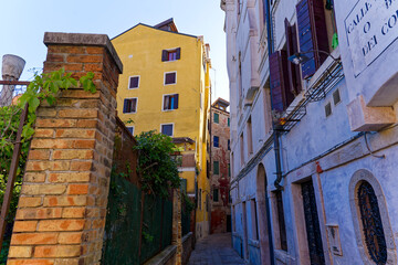 Old town of Italian City of Venice with alley with colorful weathered facades on a summer day. Photo taken August 6th, 2023, Venice, Italy.