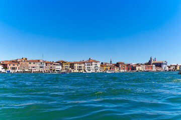 Wall Mural - Old town of Italian City of Venice with colorful facades of historic houses and church tower seen from Canale san Giorgio on a sunny summer day. Photo taken August 7th, 2023, Venice, Italy.