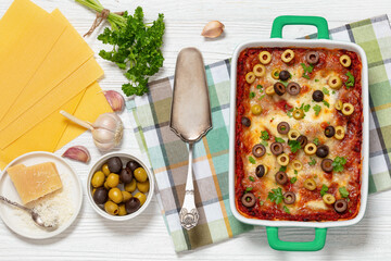 Wall Mural - lasagna with olive rings in green baking dish