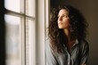 © Michael - A woman standing at a window looking into the distance.