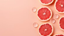 Refreshing Grapefruit Bliss: Top View Photo Of Juicy Citrus Slices, Ice Cubes, And Water Drops On Pastel Pink Background With Copy-Space For Summer Promotions