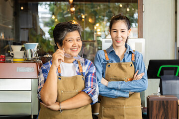 Wall Mural - Asian elderly, senior, pensioner, female open cafe restaurant small business shop at home town after retirement, healthy strong 60s mother, and barista daughter working together bonding relationship