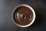 Chocolate dessert in ceramic bowl with dark chocolate pieces on concrete