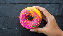 Hand Hold Donut With Blac Wood Background