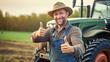 Portrait of a farmer showing a thumbs up with a tractor in the background. Agricultural work in the field