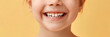 close-up of a child's smile isolated on a light yellow background, strong and healthy baby teeth