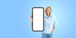 © ImageFlow - Smiling woman holding large phone blank display, isolated over white background