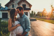 © vladim_ka - Expectant Couple Poses Proudly Outside Newly Built Home With Joyful Anticipation