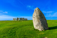 Amazing Landscape View Of The Heel Stone And Stonehenge And The Blue Sky Background On A Sunny Day. The Landmark Of England And A Popular Destination Among Tourist