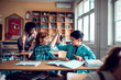 © Marko Geber - Young boys high fiving in elementary classroom