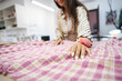 © Svitlana - Designer lays out plaid fabric on the cutting table