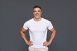 © insta_photos - Happy confident handsome fit sporty healthy mature older man, middle aged sportsman athlete or personal trainer wearing white t-shirt standing isolated on gray background advertising gym. Portrait