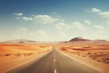 Fototapeta Góry - A desert highway disappearing into the vastness of arid dunes