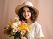 © olegganko - the young woman smiles in a straw hat while holding a bouquet of flowers