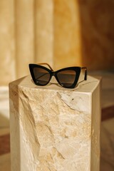 Poster - Sunglasses resting on a sleek marble block. Perfect for showcasing fashion accessories or adding a touch of sophistication to your designs
