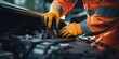 mechanic wearing orange coveralls fixing a car engine