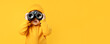© ds17 - A cheerful baby looks through binoculars on a yellow background. Banner, copyspace
