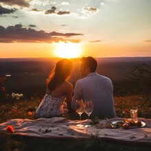 A Romantic Couple On A Picnic Sits In A Verney Together At Sunset. Romantic Dinner, Valentine's Day, Proposal
