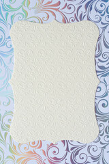 Sticker - embossed floral patterned scalloped card or frame (suitable for copy) on an elegant iridescent scrapbooking sheet with floral swirls