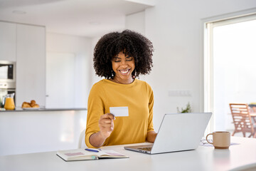 young adult smiling happy african american woman holding credit card using laptop computer paying or