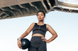 © Artem Varnitsin - Low angle shot of a confident sportswoman with medicine ball standing outdoors under a bridge