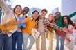 © CarlosBarquero - A large multiracial group of teenagers taking a selfie looking front camera laughing and having fun piggybacking together outdoor. Young students enjoying their free time with friends in street city