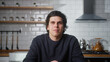© mahirkart - Young man sitting in kitchen at home talking to camera making conference business call. Video call event by work or study concept