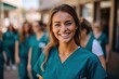 Happy young female nurse with colleagues in the background