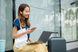 © sorapop - A beautiful woman works remotely on her laptop computer while waiting for her train. She's able to balance work and travel with ease, thanks to modern technology. new age of productivity.