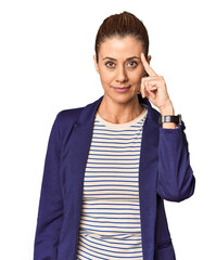 Middle-aged female entrepreneur in studio pointing temple with finger, thinking, focused on a task.