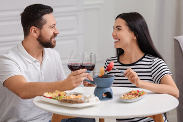 Affectionate couple enjoying chocolate fondue during romantic date at home