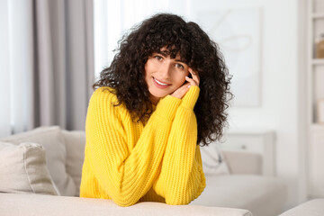 Wall Mural - Happy young woman in stylish yellow sweater indoors