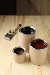 Wall Mural - Cans with different wood stains and brush on wooden surface