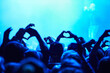 © Jeff Bergen/peopleimages.com - People, heart hands and crowd with blue light for music concert for love, support and care of artist. Audience, fans and nightlife together with gesture for unity, community or solidarity at festival