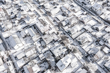 Wall Mural - aerial view from flying drone of suburb residential area, covered with snow. winter cityscape.