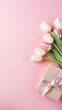 The concept of women's Day, spring, March 8, birthday. Top view of tulips and gift boxes on an isolated pastel pink background with copy space.