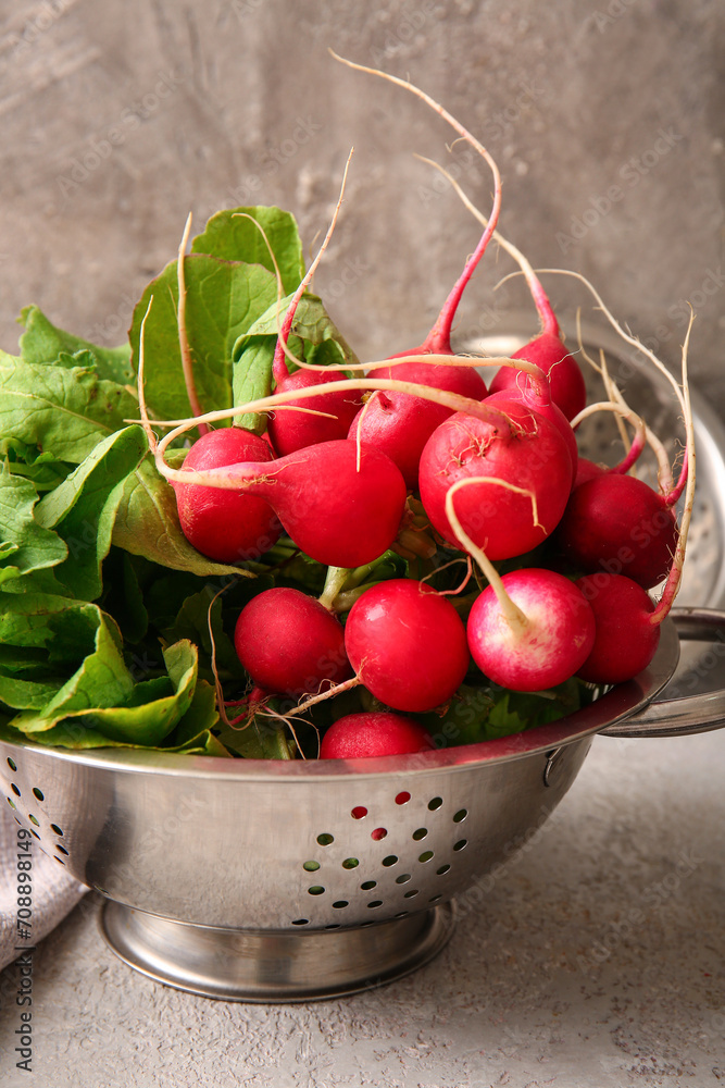 Colander with fresh radish on table