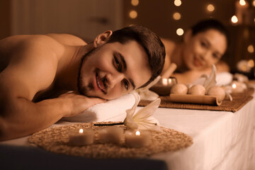 Poster - Young man with his wife relaxing in dark spa salon, closeup