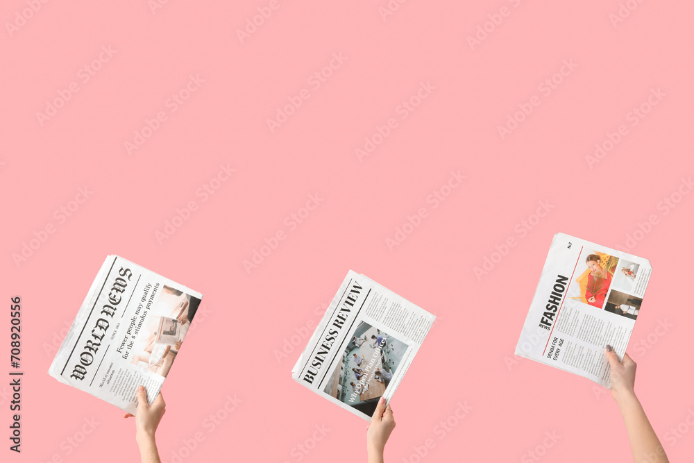 Women with newspapers on pink background