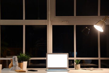 Sticker - Blank laptop and plants on desk in office at night