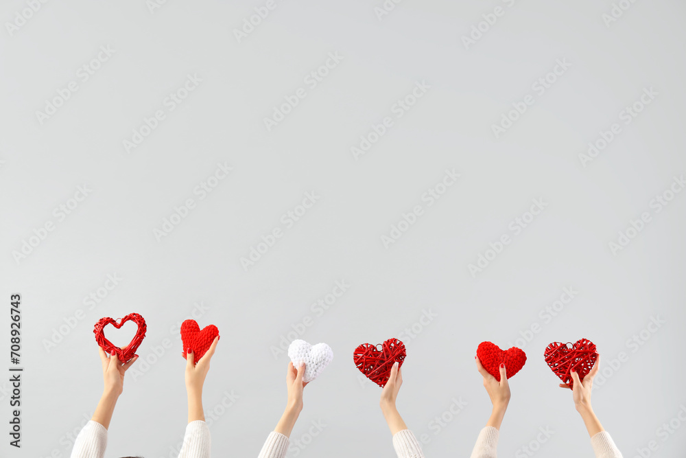 Female hands holding different hearts on white background. Valentine's Day celebration