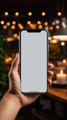 Male hand holding smartphone with blank screen on blurred background, mockup