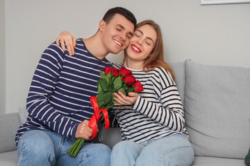 Canvas Print - Young man greeting his wife with roses at home on Valentine's Day