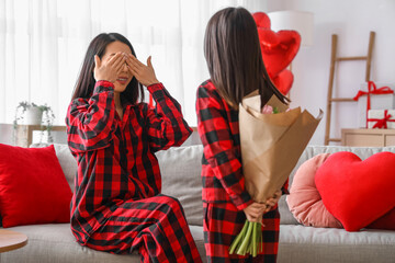 Wall Mural - Little girl greeting her mother with Valentine's day at home